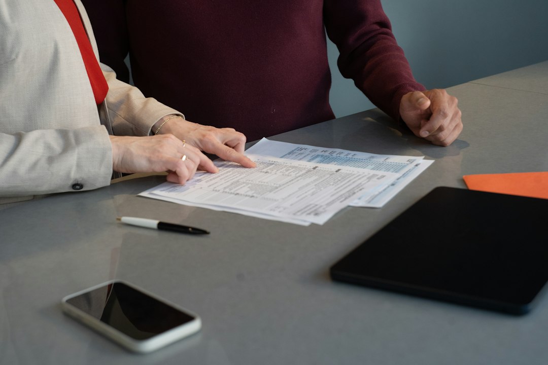 Deux professionnels examinent des documents lors d’un échange autour d’une cession d’entreprise.